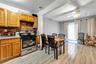 Kitchen featuring stainless steel range with gas cooktop, tasteful backsplash, brown cabinetry, and ceiling fan