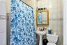 Bathroom with tile walls and a shower with shower curtain