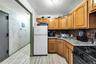 Kitchen featuring black appliances, brown cabinetry, tasteful backsplash, and wallpapered walls