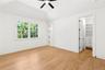 Unfurnished bedroom featuring a walk in closet, light wood finished floors, ceiling fan, recessed lighting, and lofted ceiling
