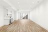 Unfurnished living room featuring recessed lighting, light wood finished floors, beverage cooler, and bar with sink