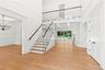 Stairway with a decorative wall, a chandelier, wainscoting, and wood finished floors