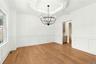 Unfurnished dining area with wood finished floors, coffered ceiling, a wainscoted wall, beam ceiling, and a chandelier