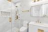 Bathroom with vanity, a stall shower, and tile walls
