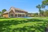 Rear view of house with a patio, an outdoor pool, and a yard