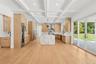 Kitchen with light stone counters, beam ceiling, modern cabinets, coffered ceiling, and light wood-type flooring