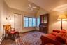 Living area featuring dark wood-style floors, ceiling fan, and high vaulted ceiling
