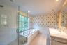 Full bath featuring wallpapered walls, tile walls, a wainscoted wall, a stall shower, and a garden tub
