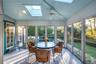 Sunroom featuring a skylight, outdoor dining area, ceiling fan, and lofted ceiling
