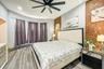 Bedroom with light wood finished floors, brick wall, a baseboard heating unit, and a ceiling fan