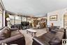 Living area with arched walkways, hanging lights, and carpet