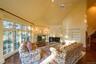 Living area with a tile fireplace, high vaulted ceiling, stairs, dark wood-type flooring, and ceiling fan