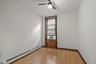 Spare room featuring a baseboard heating unit, light wood-style floors, ceiling fan, and cooling unit