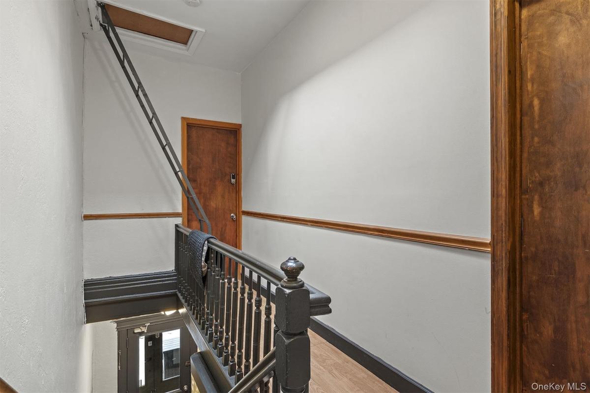 Staircase with wood finished floors and baseboards