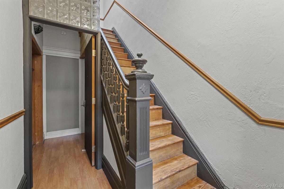 Staircase with a textured wall and wood finished floors
