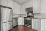 Kitchen with appliances with stainless steel finishes, white cabinets, dark wood-style floors, decorative backsplash, and recessed lighting