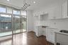 Kitchen with white cabinetry, hanging light fixtures, dark wood finished floors, light stone counters, and recessed lighting