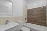 Full bath featuring shower / washtub combination, vanity, and tile walls