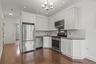 Kitchen with stainless steel appliances, white cabinets, backsplash, a chandelier, and recessed lighting
