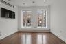 Spare room featuring an AC wall unit, baseboard heating, dark wood-type flooring, and recessed lighting