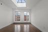 Empty room with a skylight, dark wood-style floors, and recessed lighting