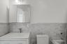 Full bathroom featuring a tub to relax in, vanity, a wainscoted wall, and tile walls