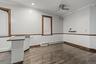 Spare room featuring ornamental molding, baseboard heating, dark wood-style floors, and ceiling fan