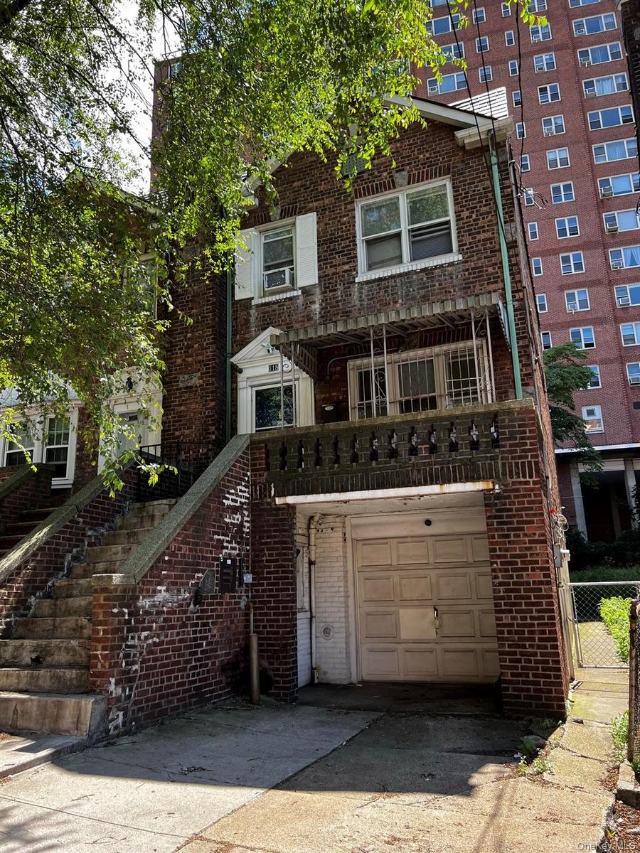 View of front of house with brick siding, stairs, concrete driveway, a balcony, and an attached garage