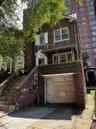 View of front of house with brick siding, stairs, concrete driveway, a balcony, and an attached garage