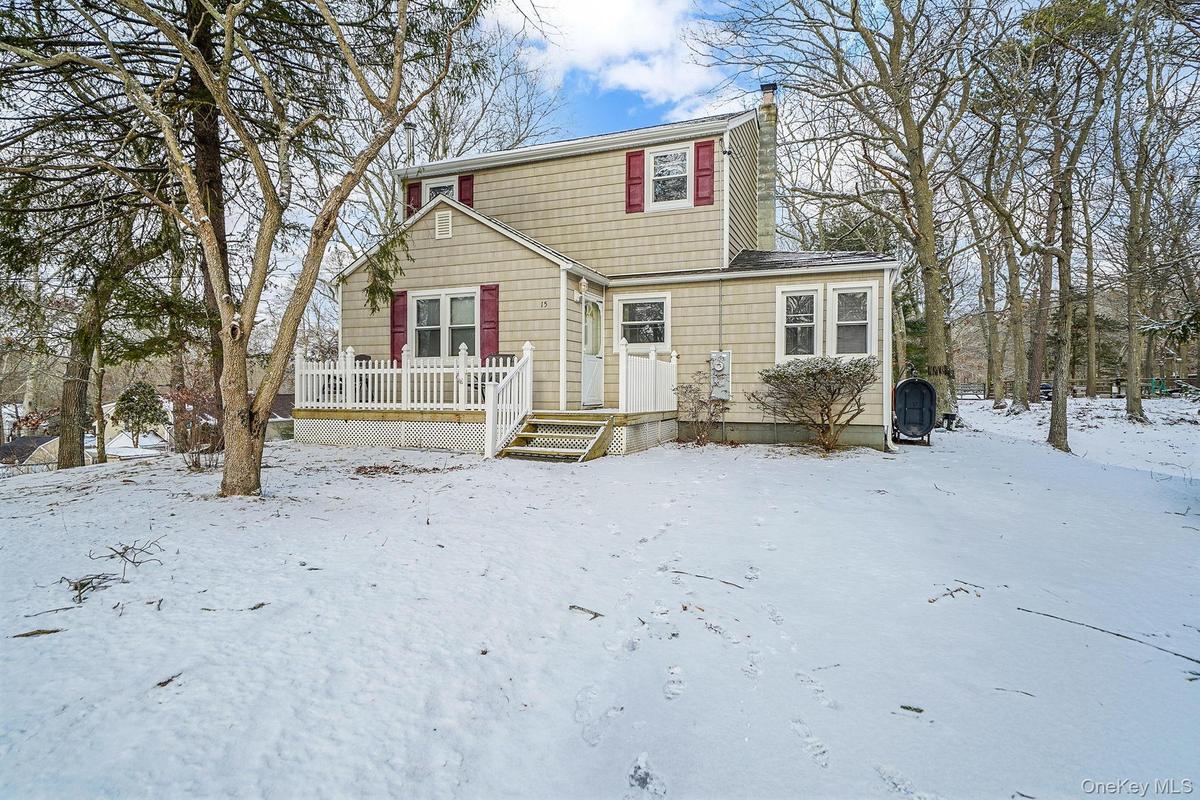 View of front of property featuring a wooden deck, a chimney, and heating fuel