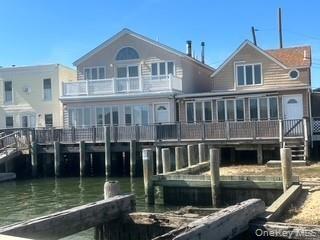 Rear view of property with a sunroom and a water view