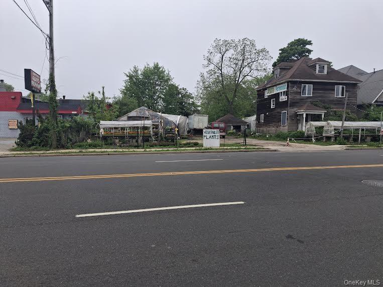 View of asphalt street featuring curbs and sidewalks