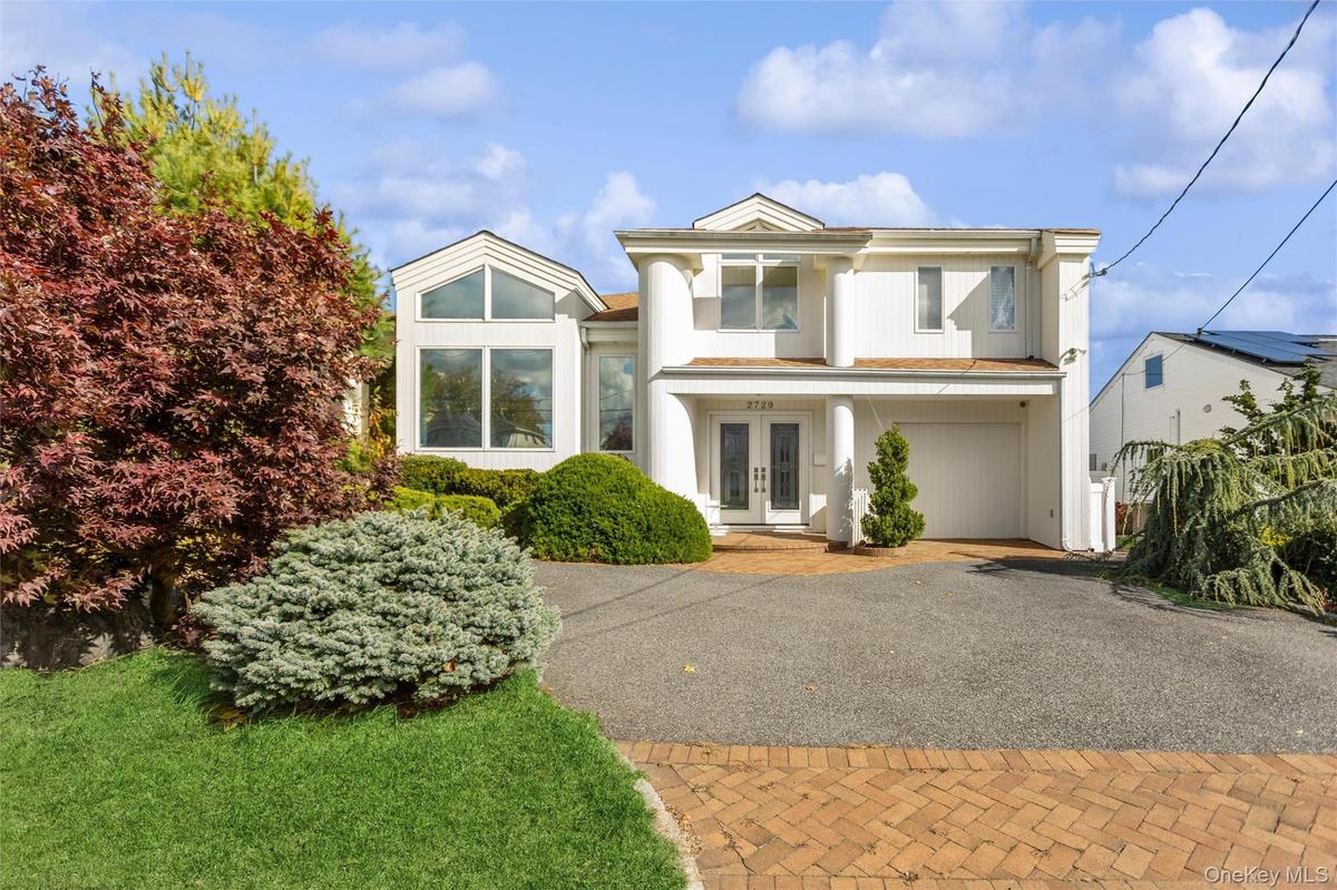 View of front of home with french doors and decorative driveway
