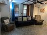 Living room featuring stone flooring and a ceiling fan
