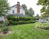 The expansive, fenced-in yard features lovely gardens