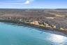 Wide aerial perspective of the North Fork shoreline, showcasing the property’s waterfront setting along the bluff, neighboring homes, and expansive op