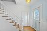 Entryway with a wainscoted wall, ornamental molding, a decorative wall, light wood-style floors, and stairs