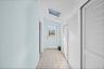 Corridor of closets featuring a skylight, vaulted ceiling