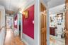 Corridor with attic access, a textured wall, and ornamental molding