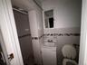 Full bath with a shower stall, vanity, tile walls, and wainscoting