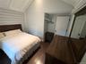 Bedroom with dark wood finished floors and baseboards