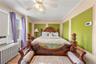 Bedroom with radiator, crown molding, wood finished floors, ceiling fan, and cooling unit