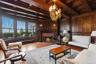 Parlor with wood millwork walls, a wood ceiling with exposed beams, brick fireplace, custom mermaid chandelier, and original oak floors