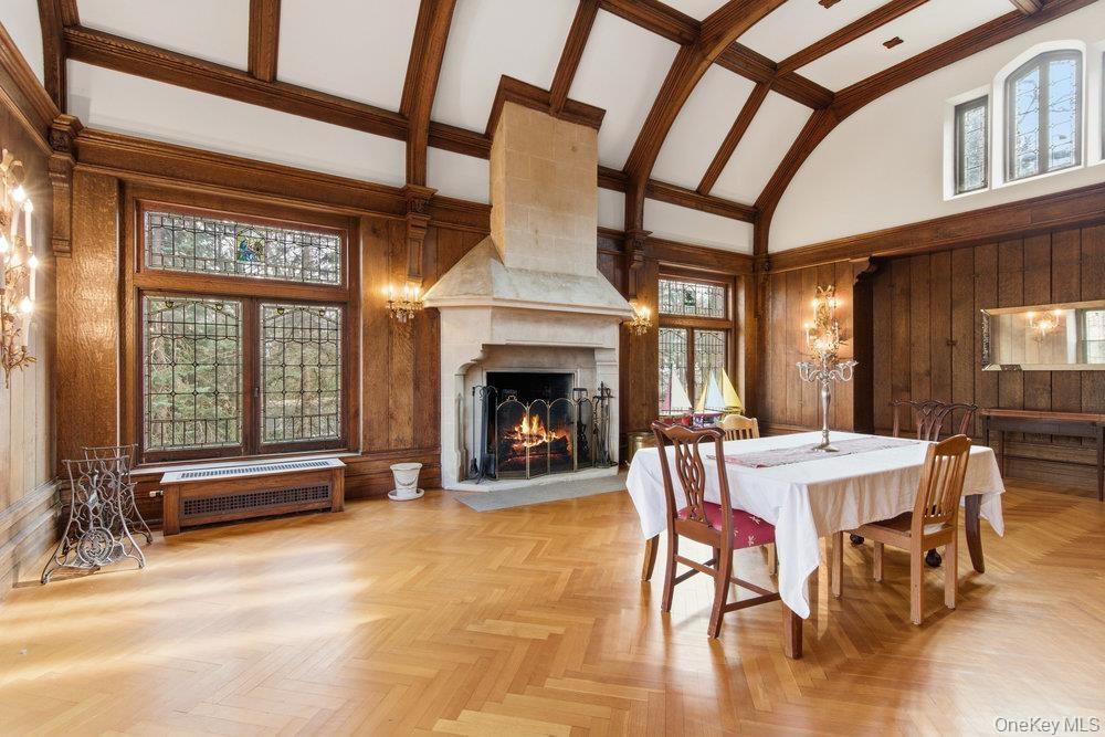 Banquet sized Dining room with high vaulted ceiling,   and a large fireplace, leaded glass windows with stained glass accents