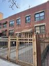 Townhome / multi-family property with cooling unit, brick siding, a gate, and a fenced front yard