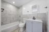 Full bathroom with tile walls, vanity, shower / washtub combination, and tile patterned floors