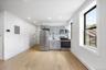 Kitchen featuring gray cabinetry, appliances with stainless steel finishes, light wood finished floors, electric panel, and light countertops