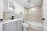 Full bath with tile walls, vanity, washtub / shower combination, tile patterned flooring, and recessed lighting