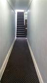 Hallway with carpet floors and baseboards