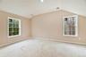 Spare room featuring baseboards and lofted ceiling
